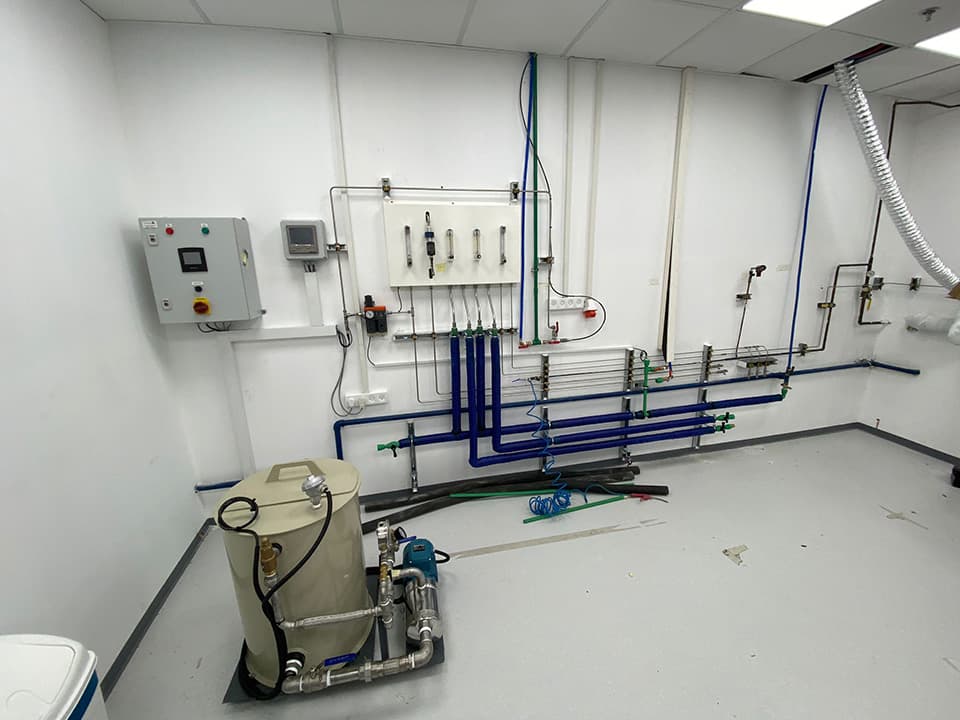 Room with a control cabinet, blue lines and a pump