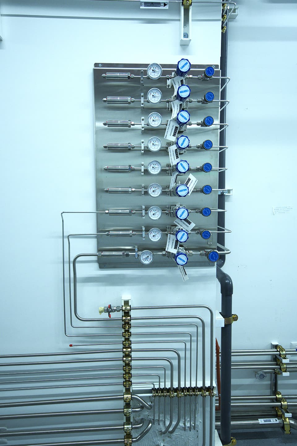 Panel with a manifold and drops behind glass