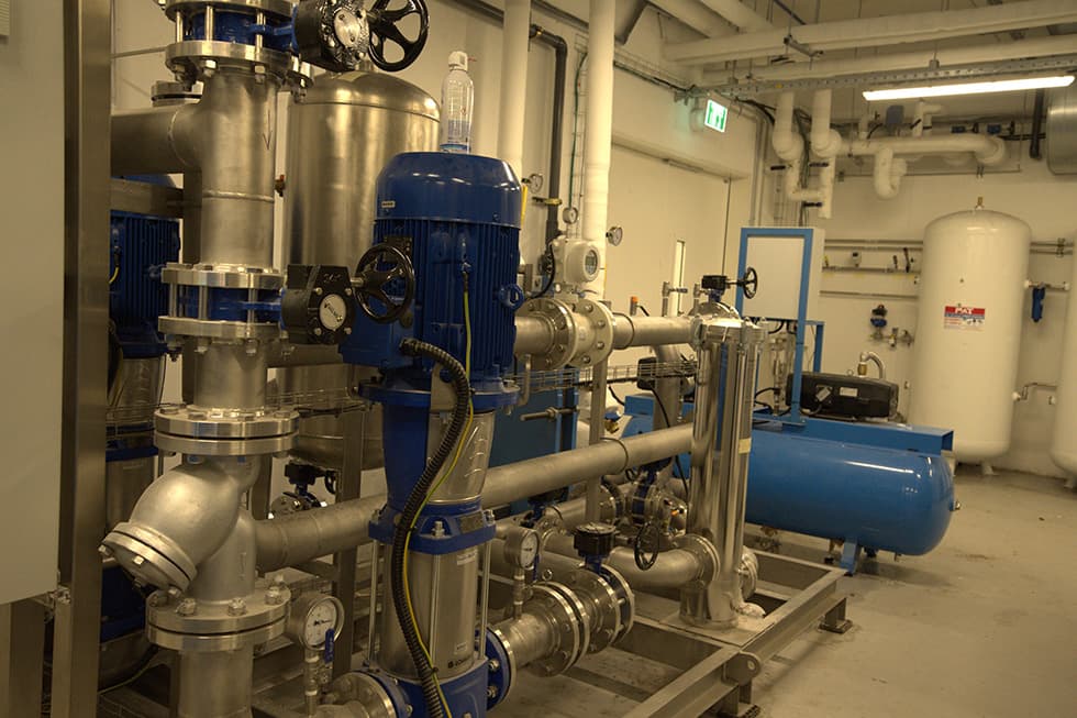 A plant room with vertical pumps, filters and pressure vessels